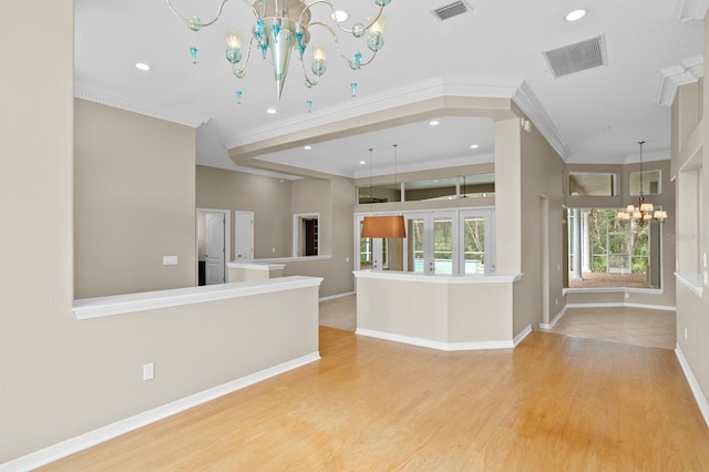 kitchen featuring pendant lighting, ornamental molding, a chandelier, and light wood-type flooring