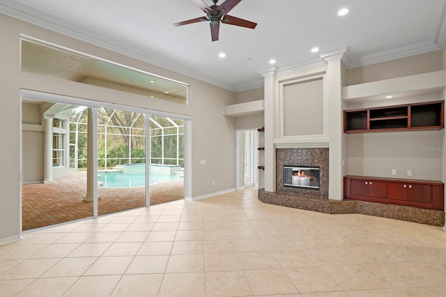 unfurnished living room with ceiling fan, light tile patterned floors, a fireplace, and crown molding