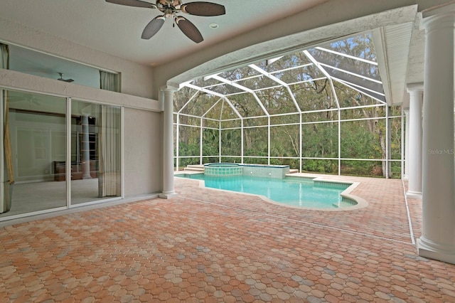 view of swimming pool featuring ceiling fan, glass enclosure, a patio area, and an in ground hot tub