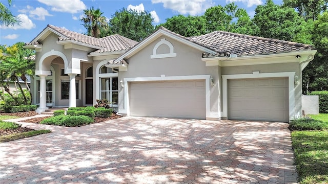 10106 Radcliffe Dr, Tampa, FL 33626 - mediterranean / spanish-style house with stucco siding, a tiled roof, and a garage