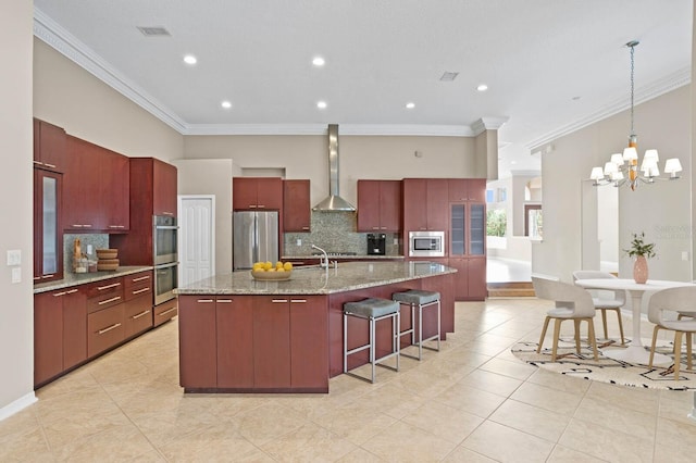 10106 Radcliffe Dr, Tampa, FL 33626 - kitchen featuring stainless steel appliances, wall chimney exhaust hood, tasteful backsplash, crown molding, and reddish brown cabinets
