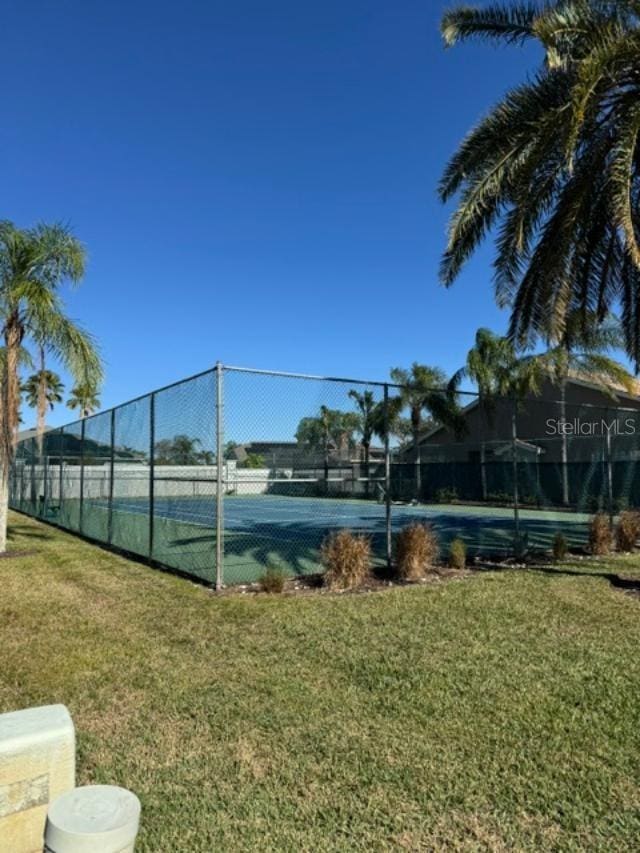 view of sport court with a lawn