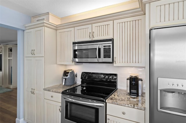 kitchen with cream cabinetry, decorative backsplash, and appliances with stainless steel finishes