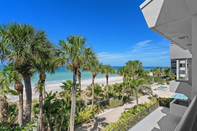 balcony with a water view and a view of the beach