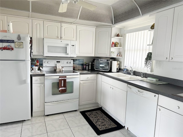 kitchen featuring white cabinets, light tile patterned flooring, white appliances, and sink