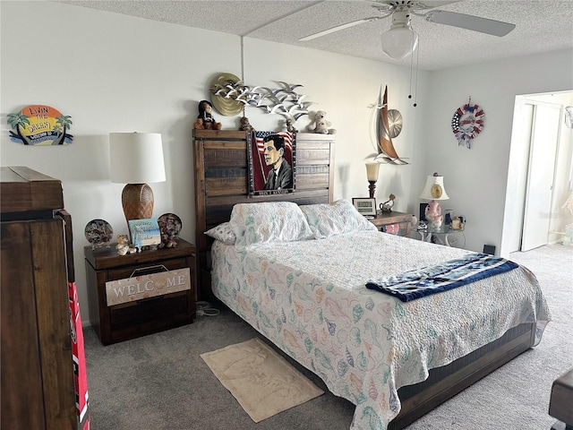 carpeted bedroom featuring ceiling fan and a textured ceiling