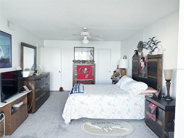 bedroom featuring ceiling fan, carpet floors, and a textured ceiling