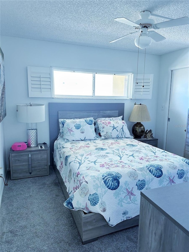 carpeted bedroom featuring ceiling fan and a textured ceiling