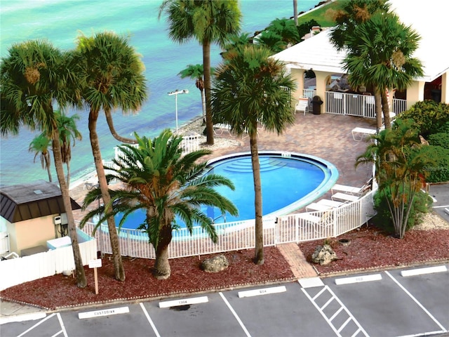 view of swimming pool featuring a water view and a patio