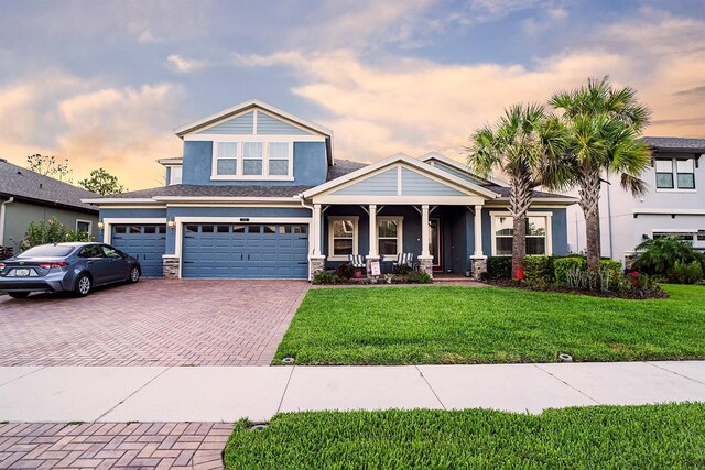 craftsman house with covered porch, a yard, and a garage