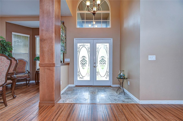 entrance foyer featuring a chandelier, light wood-type flooring, and french doors