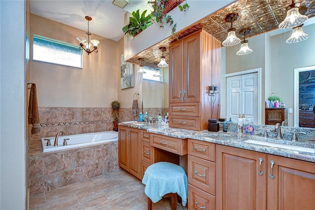 bathroom with vanity, tiled bath, and an inviting chandelier