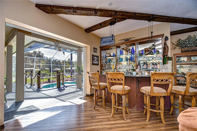 bar featuring wood-type flooring and beam ceiling