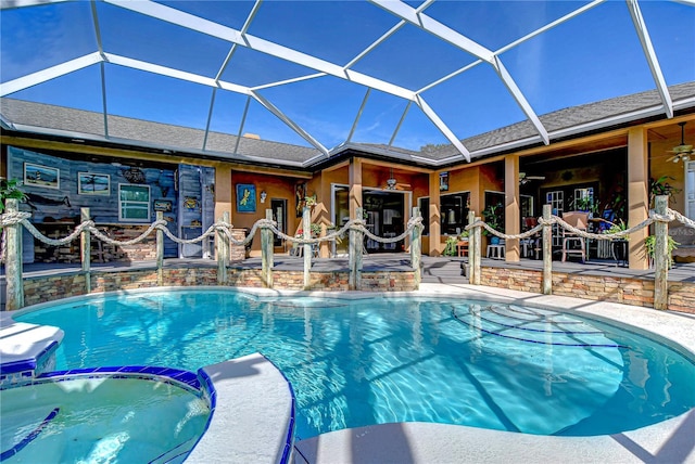 view of pool with a patio area, ceiling fan, and glass enclosure