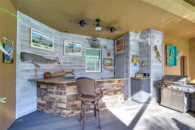 exterior space with a bar, area for grilling, and ceiling fan