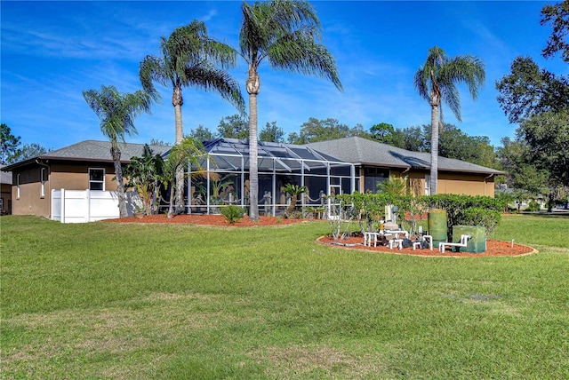 back of house with a lanai and a lawn