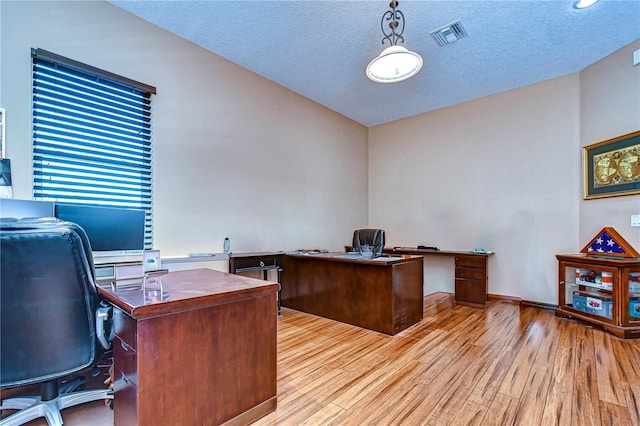 office space featuring light hardwood / wood-style flooring and a textured ceiling