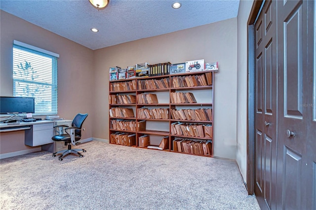 carpeted office featuring a textured ceiling