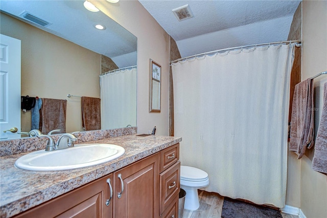 bathroom with hardwood / wood-style flooring, vanity, a textured ceiling, and toilet