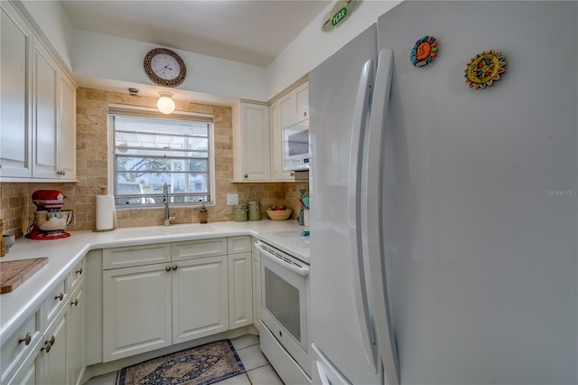 kitchen with white cabinets, white appliances, sink, and tasteful backsplash