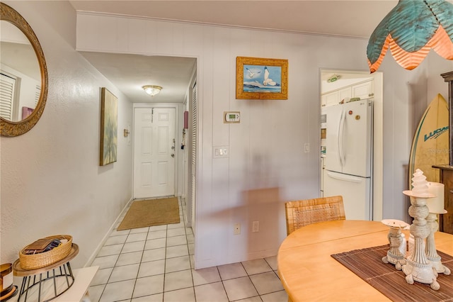 interior space with white cabinets, white fridge, and light tile patterned flooring