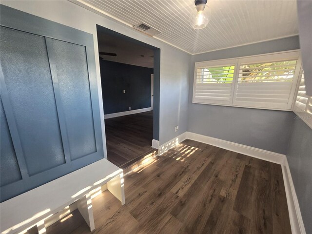 empty room featuring wood ceiling, dark wood-type flooring, visible vents, and baseboards