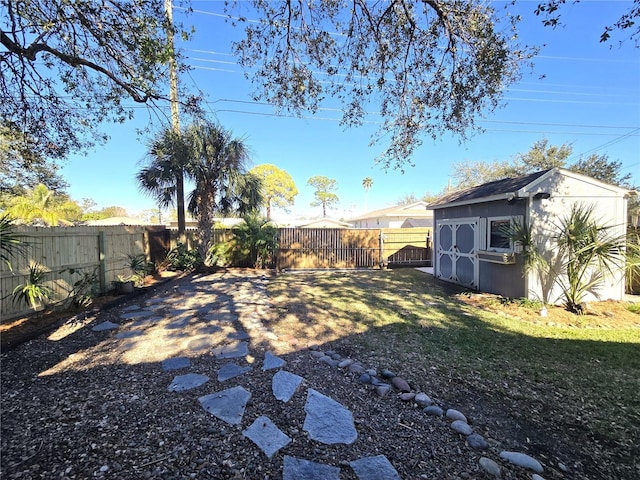 view of yard with a storage unit, an outdoor structure, and a fenced backyard