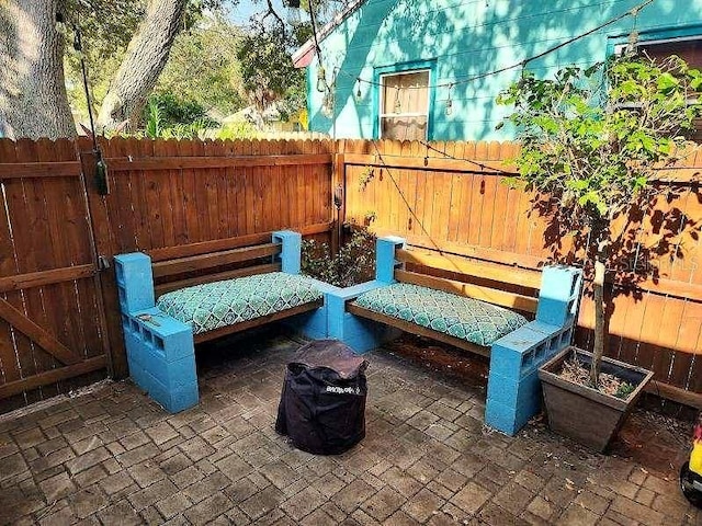 view of patio featuring fence and a gate