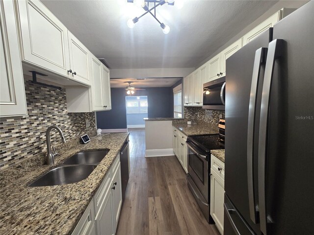 kitchen featuring light stone counters, appliances with stainless steel finishes, a sink, and white cabinetry