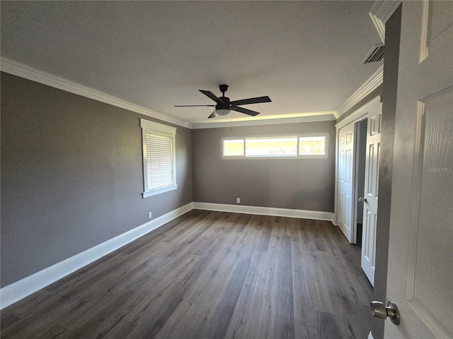 spare room with baseboards, dark wood finished floors, a ceiling fan, and ornamental molding