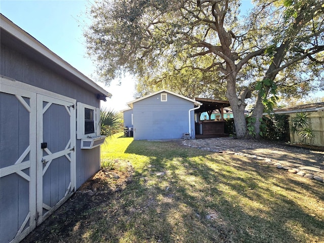 view of yard with a storage shed, fence, and an outbuilding