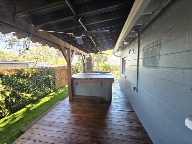 wooden terrace featuring a hot tub, fence, and a ceiling fan