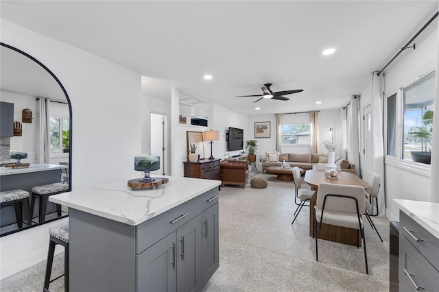 kitchen with plenty of natural light, a kitchen island, ceiling fan, and gray cabinetry