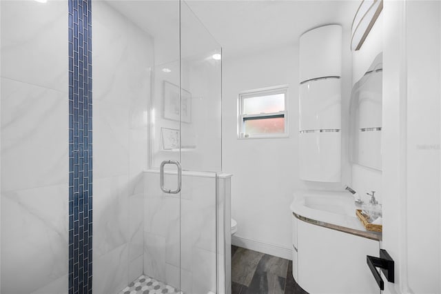 bathroom featuring vanity, hardwood / wood-style flooring, toilet, and an enclosed shower