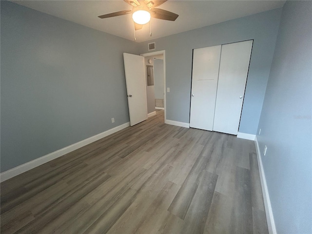 unfurnished bedroom with ceiling fan, wood-type flooring, and a closet