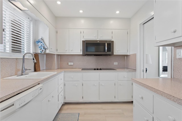 kitchen with white cabinets, sink, white dishwasher, and black electric stovetop