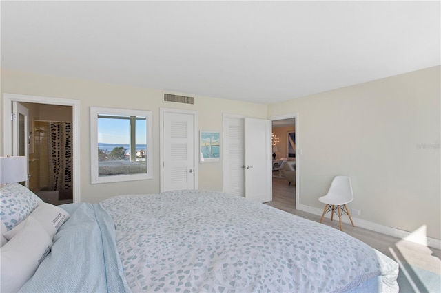 bedroom featuring connected bathroom and hardwood / wood-style flooring