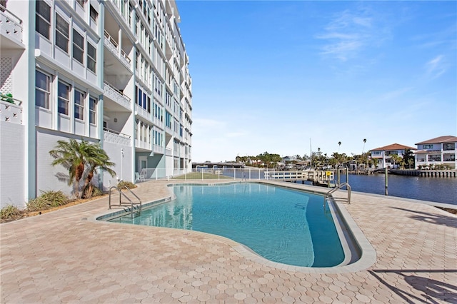 view of swimming pool featuring a patio area and a water view