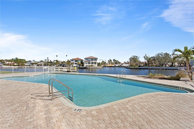 view of pool with a patio area and a water view