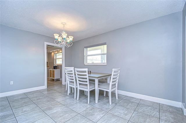 unfurnished dining area featuring a textured ceiling and an inviting chandelier