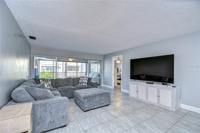 living room featuring ceiling fan and a textured ceiling