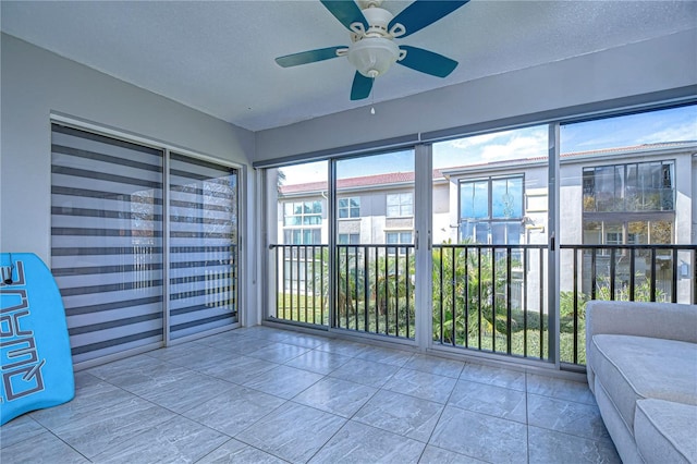 unfurnished sunroom featuring ceiling fan