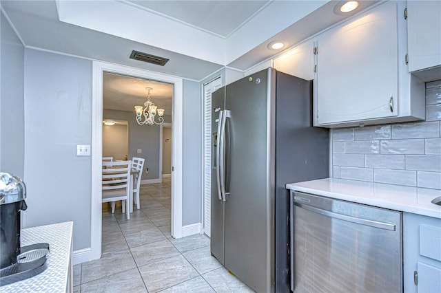 kitchen featuring tasteful backsplash, an inviting chandelier, light tile patterned floors, and appliances with stainless steel finishes