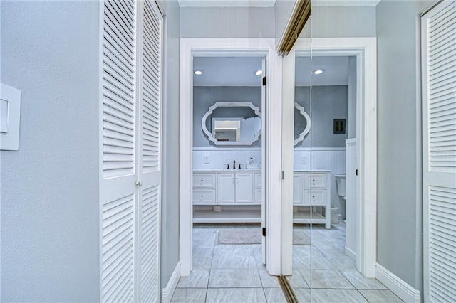 corridor with sink and light tile patterned floors