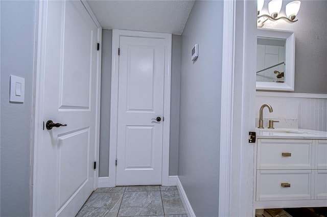 interior space with light tile patterned flooring, a textured ceiling, and sink