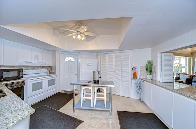 kitchen featuring black appliances, white cabinetry, and a tray ceiling