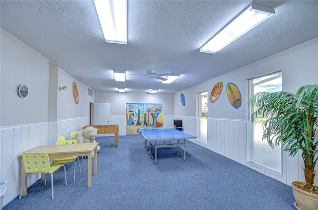 playroom featuring carpet flooring, ceiling fan, and a textured ceiling