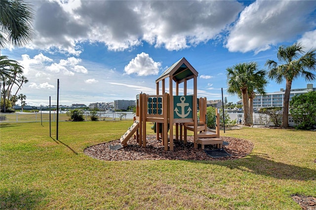 view of playground with a lawn and a water view