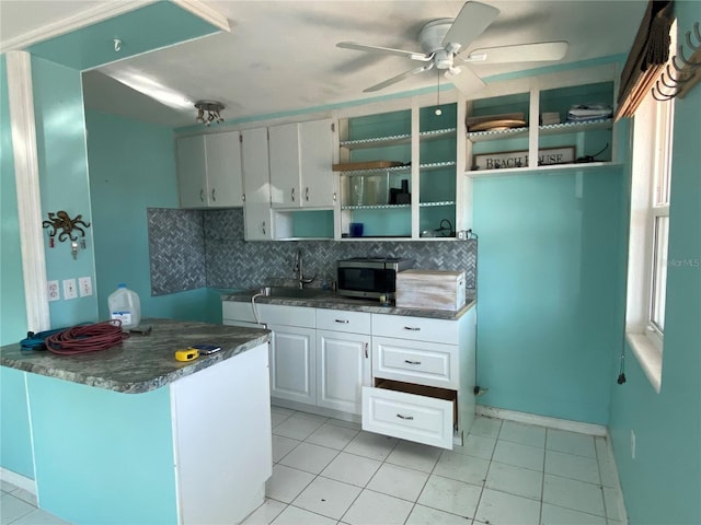 kitchen featuring tasteful backsplash, ceiling fan, sink, white cabinetry, and light tile patterned flooring