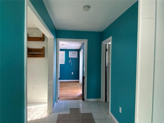 corridor with light tile patterned floors and a wall mounted air conditioner